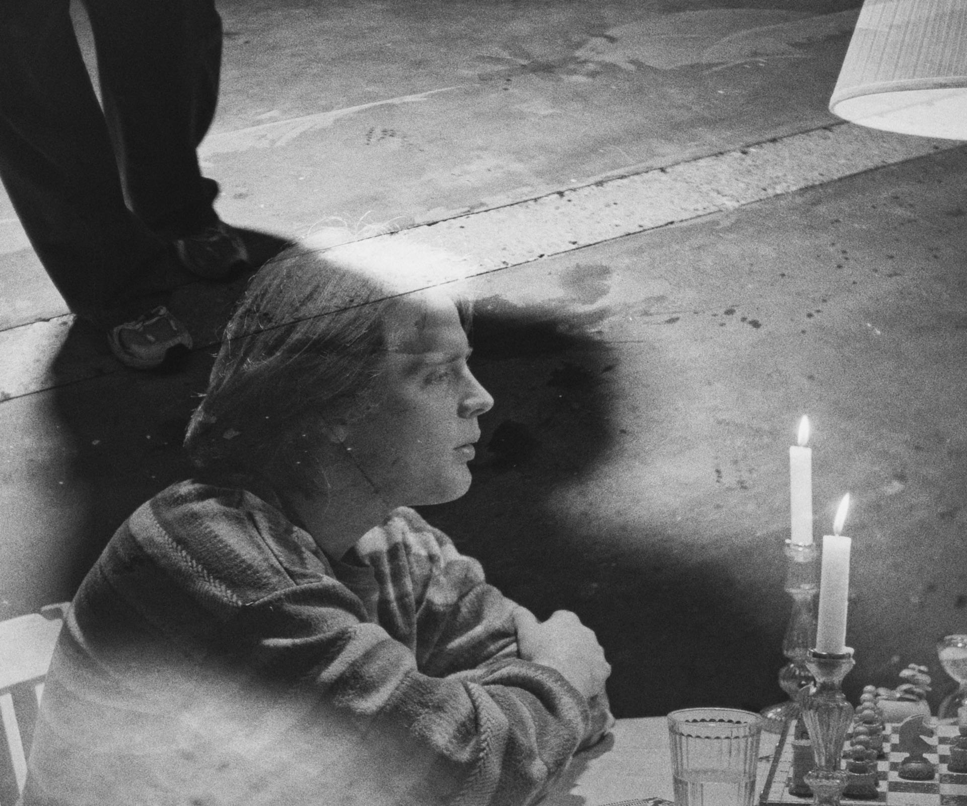 Black and white, overhead: Ivo Martin leans on the table, burning candles beside him