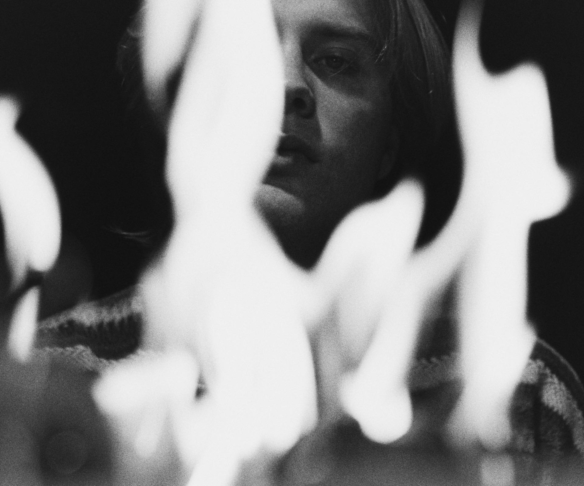 Ivo Martin's face behind blurred flickering flames, black and white