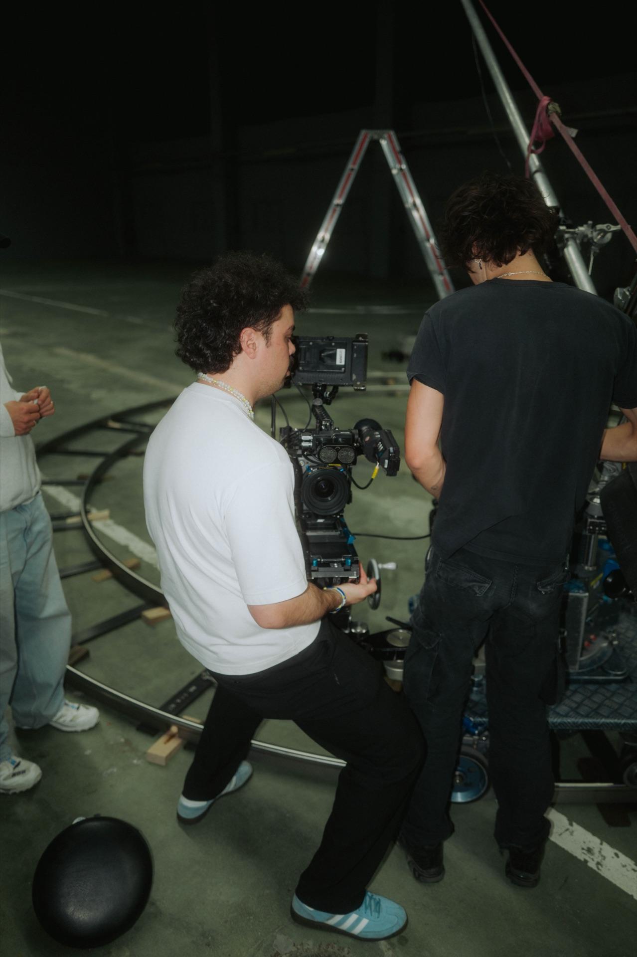 Cinematographer moves the ARRI on the dolly, a crew member counterbalancing
