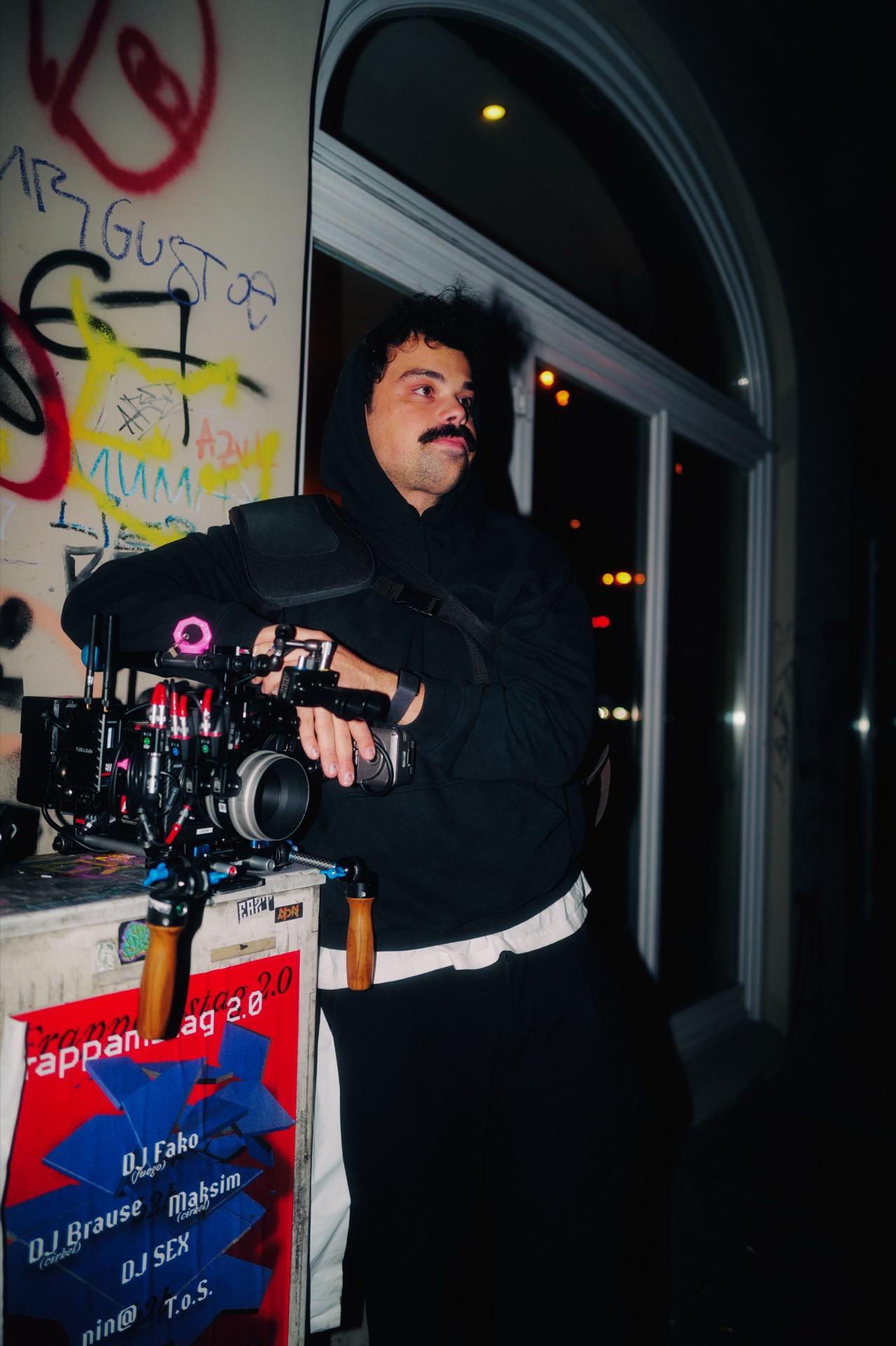 Behind the Scenes: DOP Lino Kalkhoff mit dem Kamera-Rig vor einer Graffiti-Wand bei Nacht