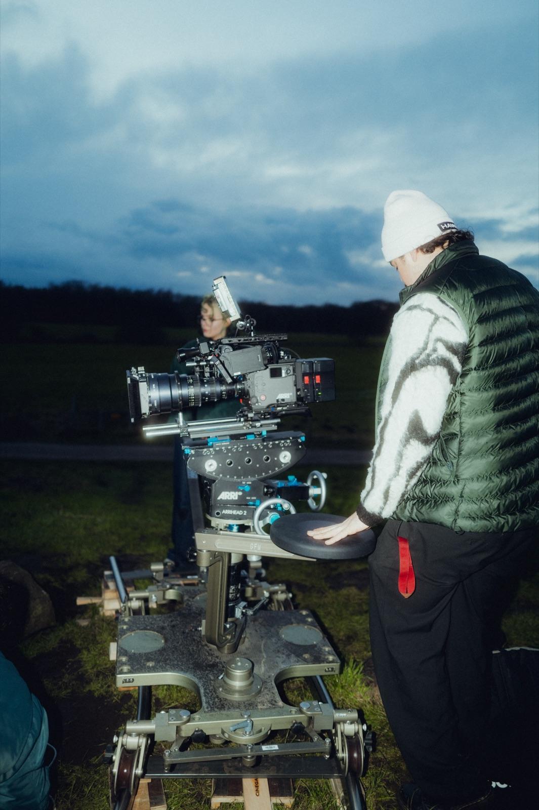 Behind the Scenes: zwei Operator an der ARRI auf dem Dolly in der Dämmerung, einer in Felljacke