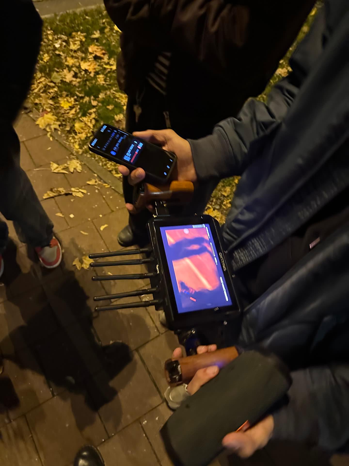 Behind the Scenes: Funkmonitor und Steuerung in den Händen der Crew am nächtlichen Set