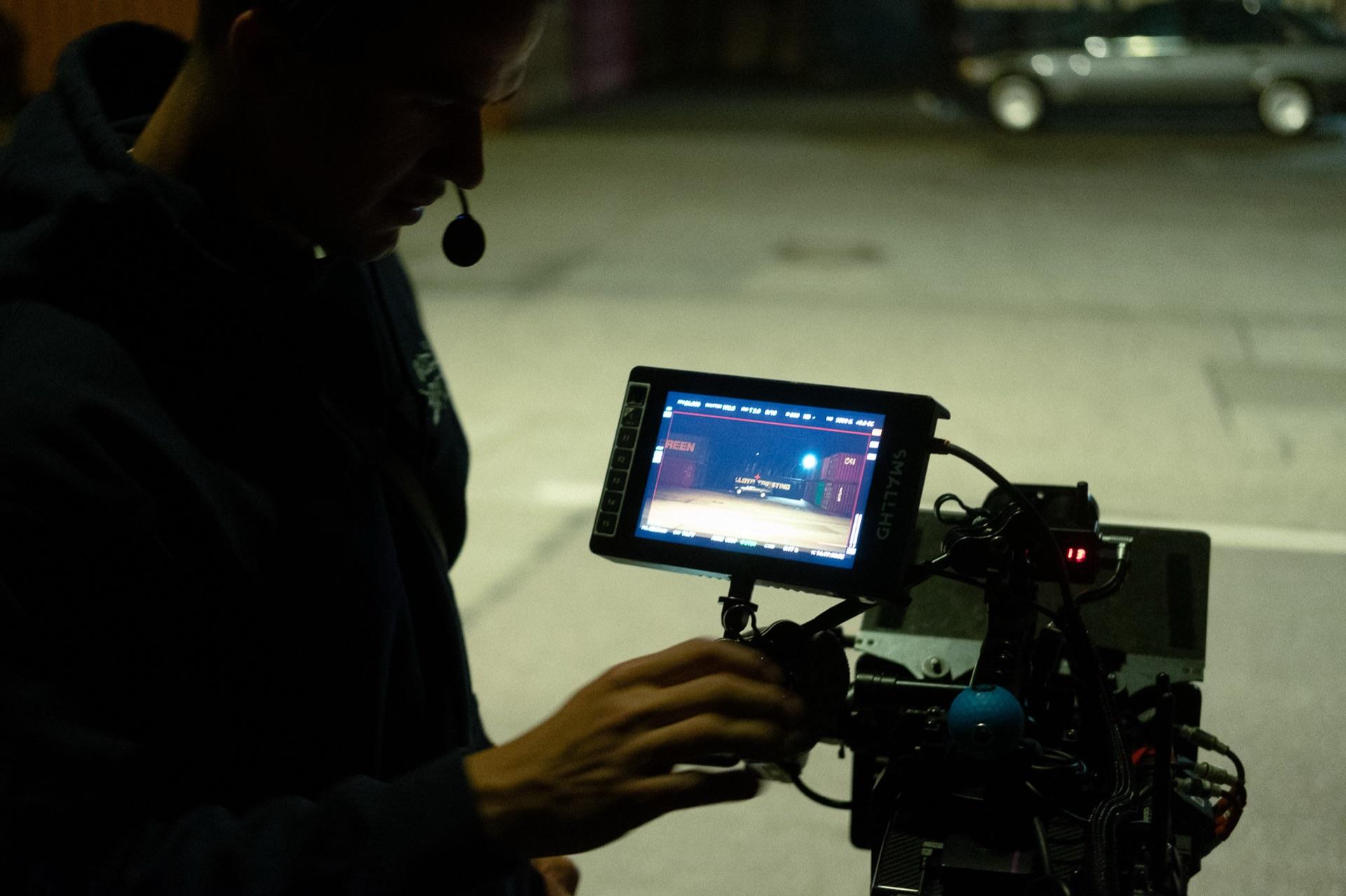 Behind the scenes: the camera operator with a headset focuses while adjusting the camera on the rig