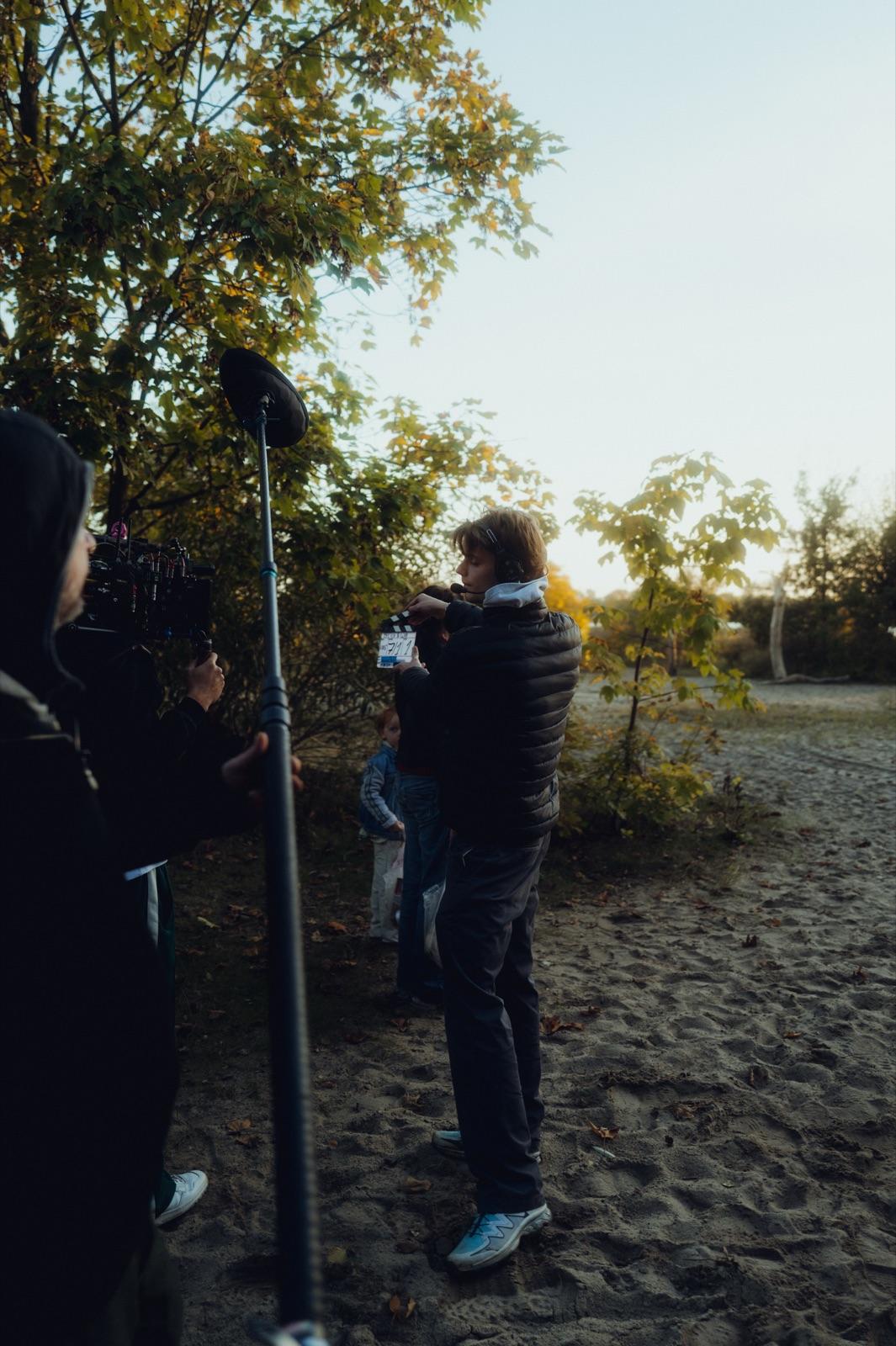 Behind the Scenes: der Kameramann filmt im goldenen Abendlicht am Strand, daneben die Tonangel