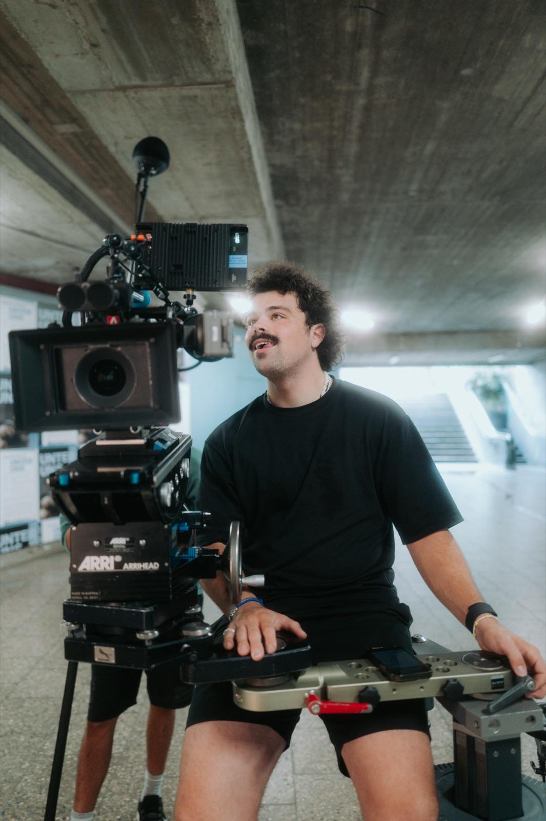 Behind the Scenes: der Operator hinter der ARRI blickt lächelnd nach oben in der Unterführung