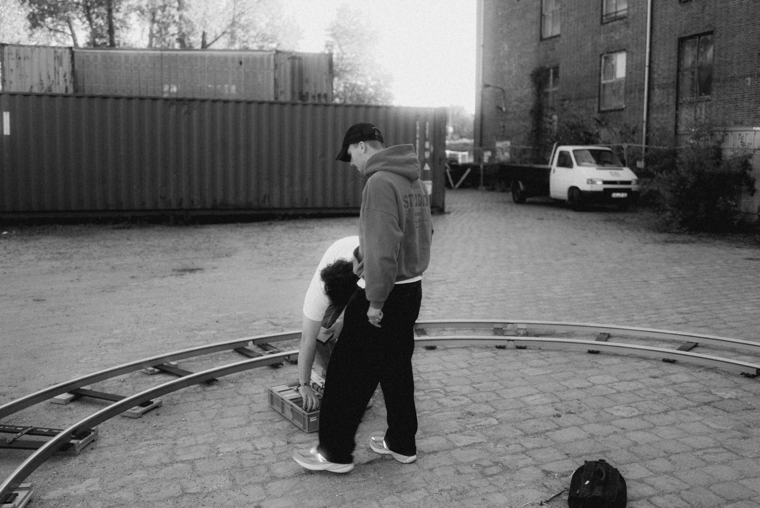 Zwei Crewmitglieder bauen in einem Hof eine runde Dolly-Schiene auf