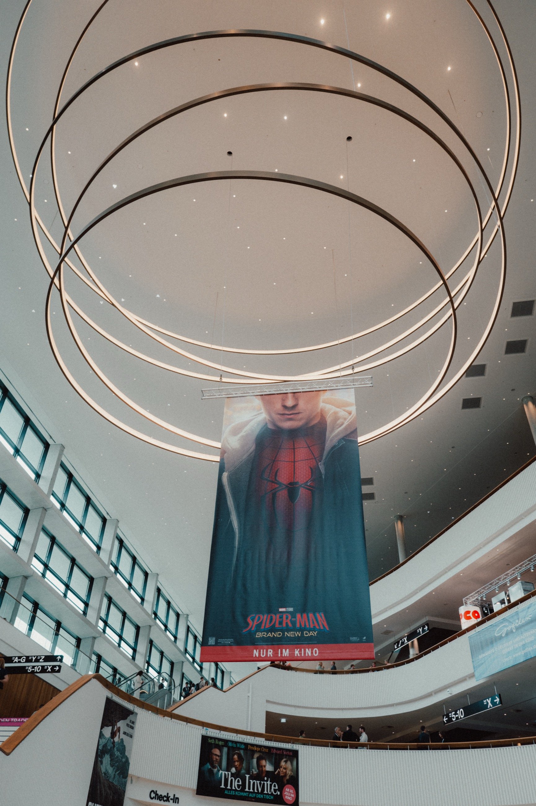 Foyer des CCH mit runden Deckenleuchten, darunter hängt ein großes Spider-Man Banner mit der Zeile Nur im Kino