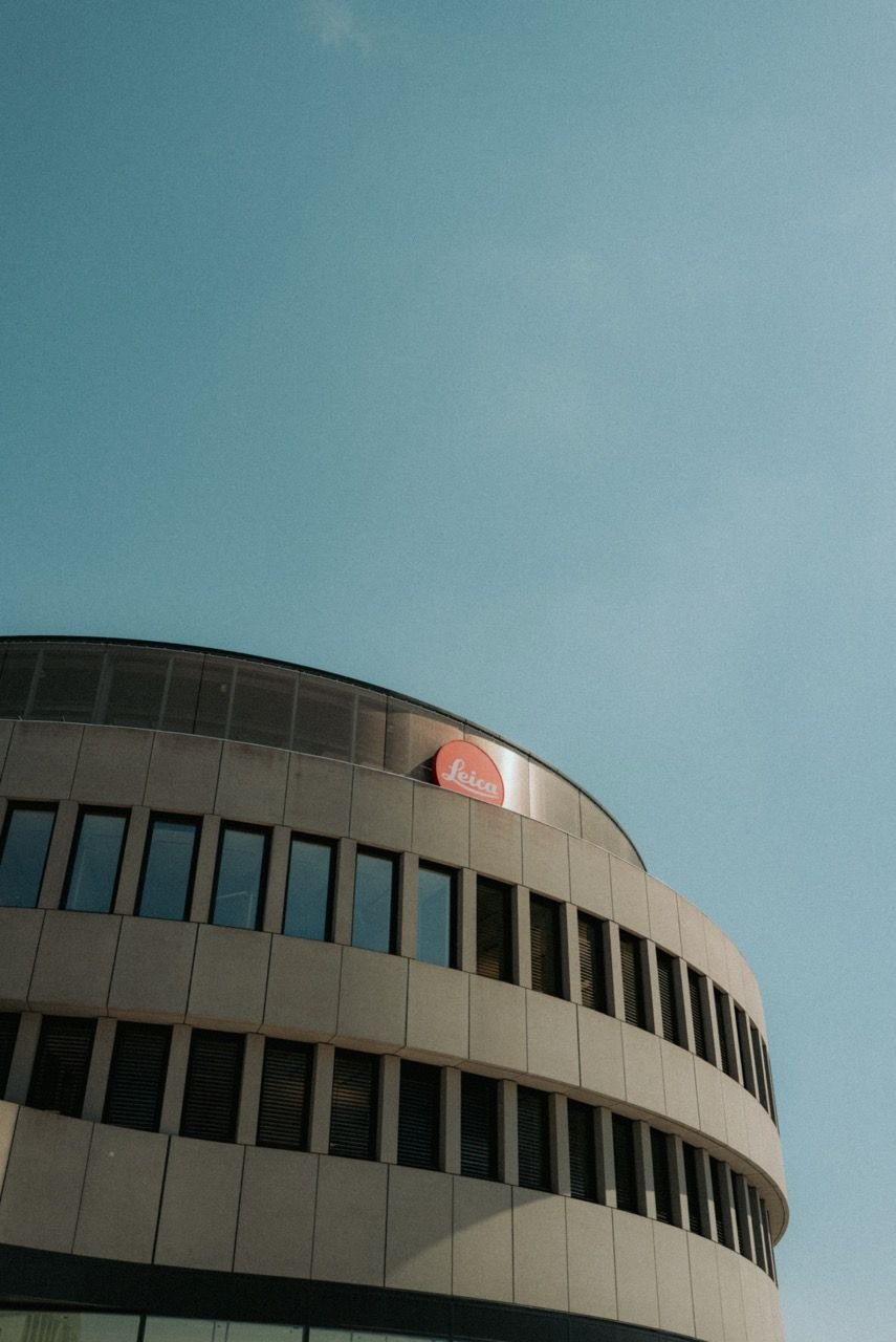 Round building of the Leitz-Park with a red Leica dot on its upper edge, blue sky above