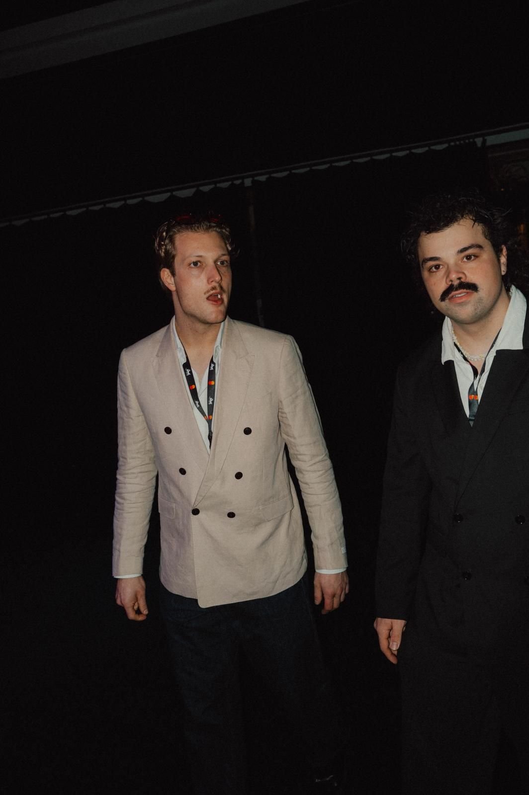 Two people with accreditation lanyards talking at the Berlinale