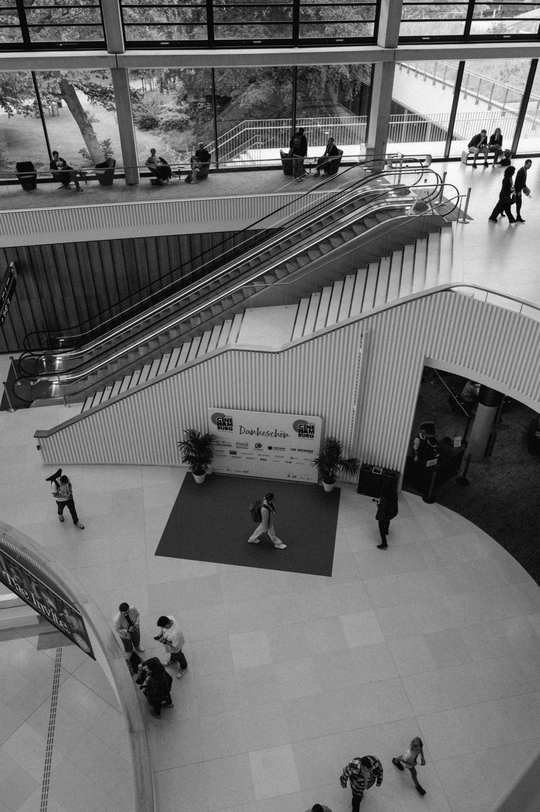 Schwarzweiß Aufnahme der Rolltreppen im CCH, unten eine Fotowand mit dem Schriftzug Dankeschön