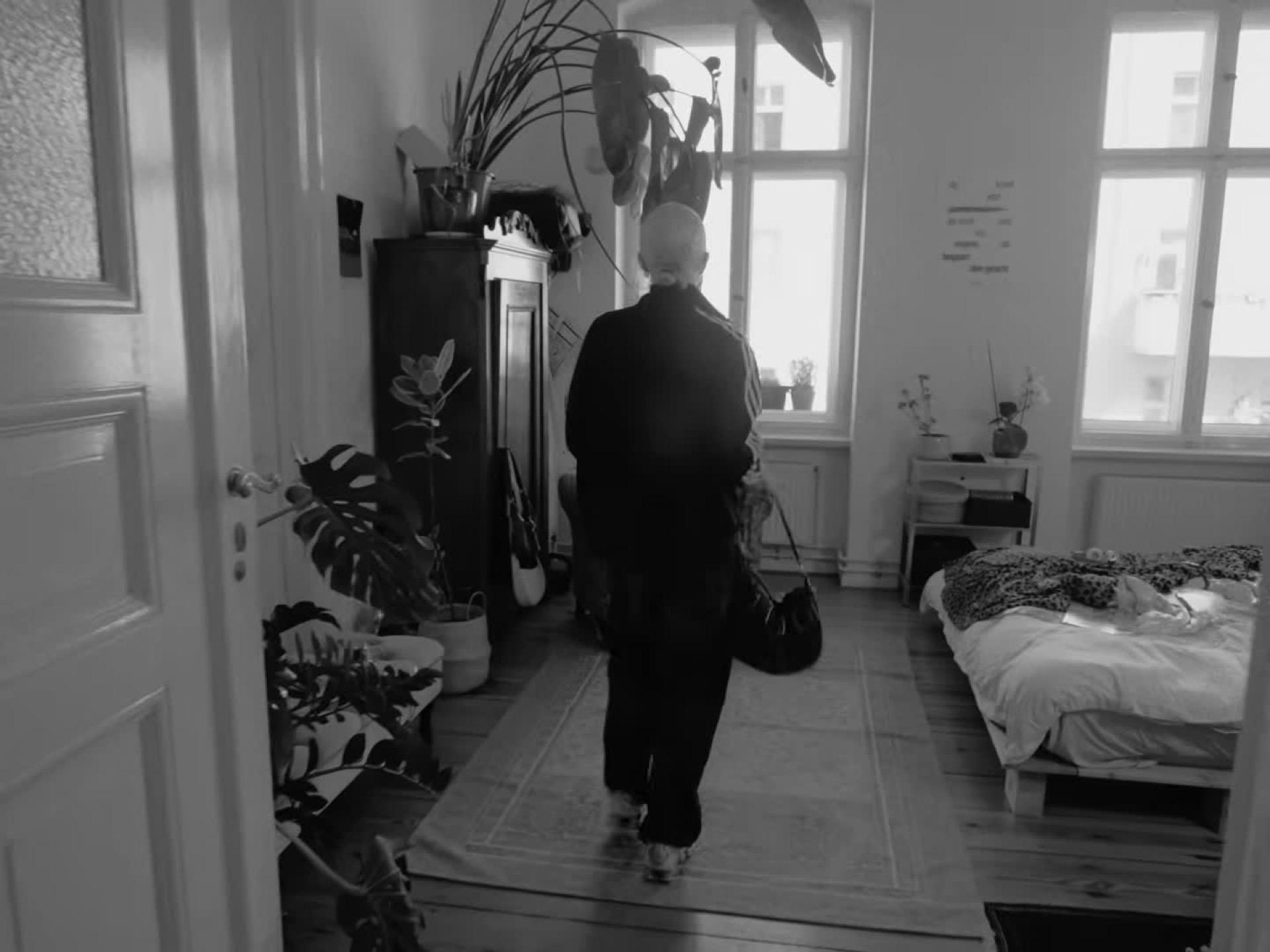 Schwarzweiß: eine Person als Silhouette vor hellen Fenstern im Schlafzimmer