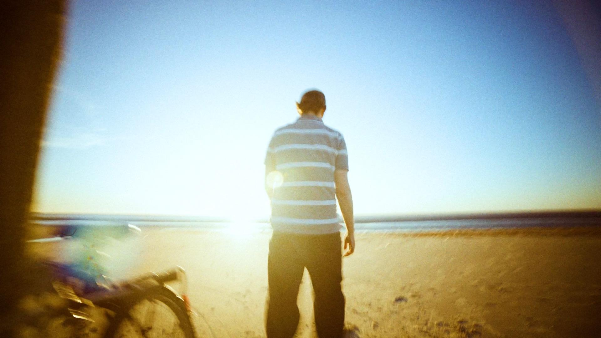 Person als Silhouette vor der gleißenden Abendsonne