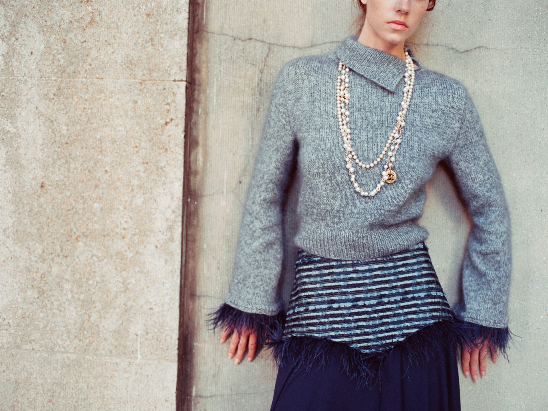 A knit dress with fringes and long strings of pearls