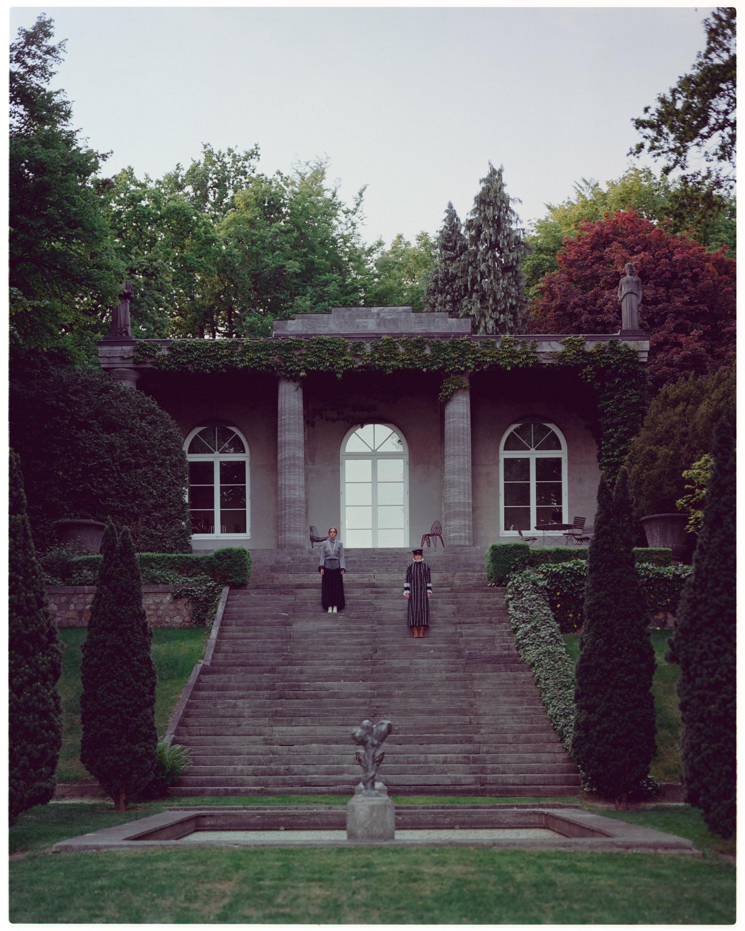 Two models as silhouettes in front of a garden pavilion in the park