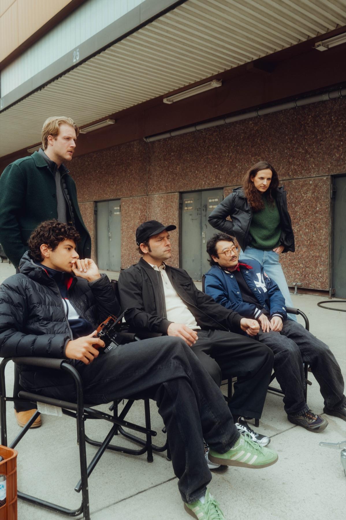 Crew and cast wait on director's chairs on set