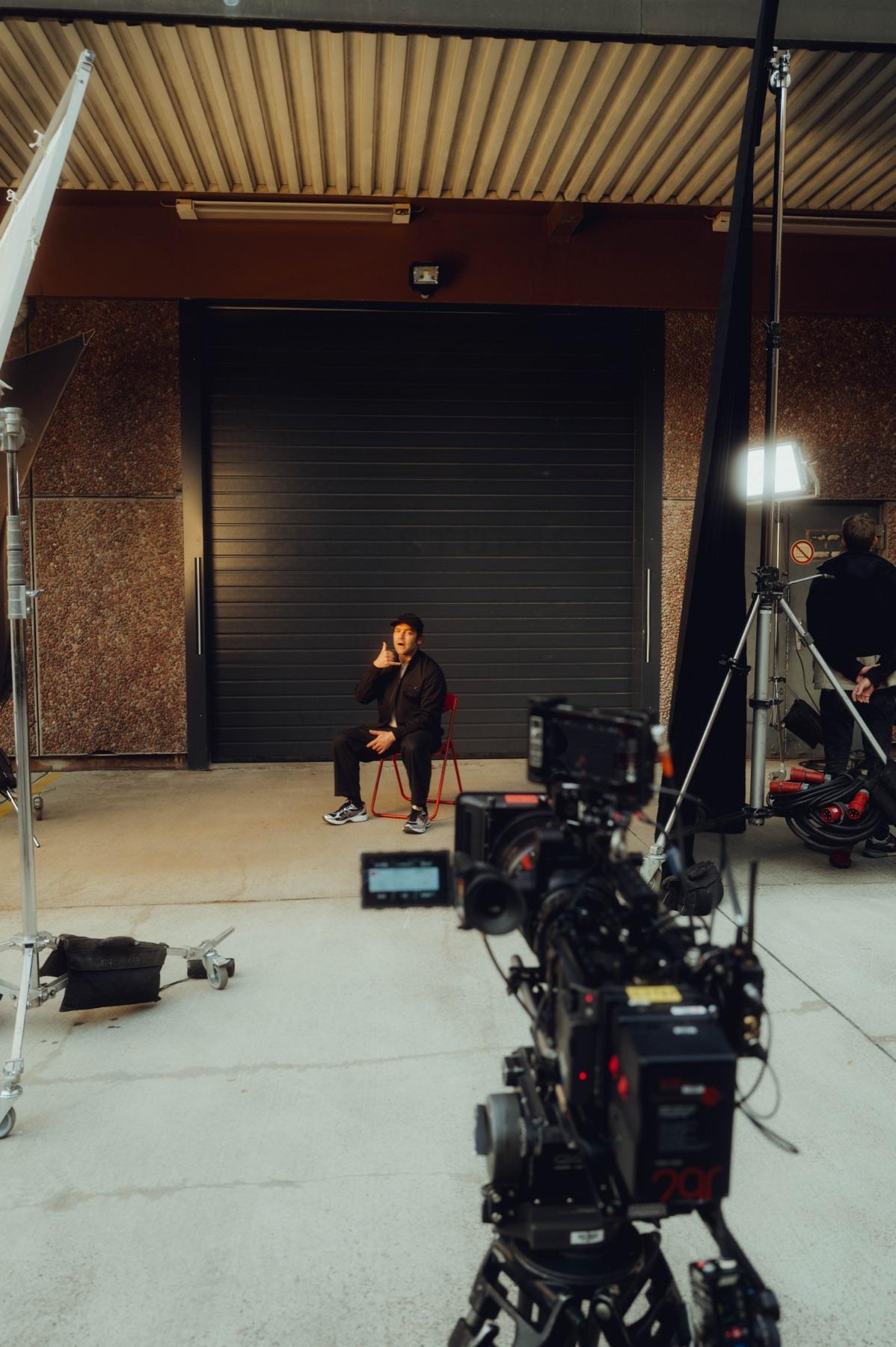 Bosse on a red chair in front of the camera on set