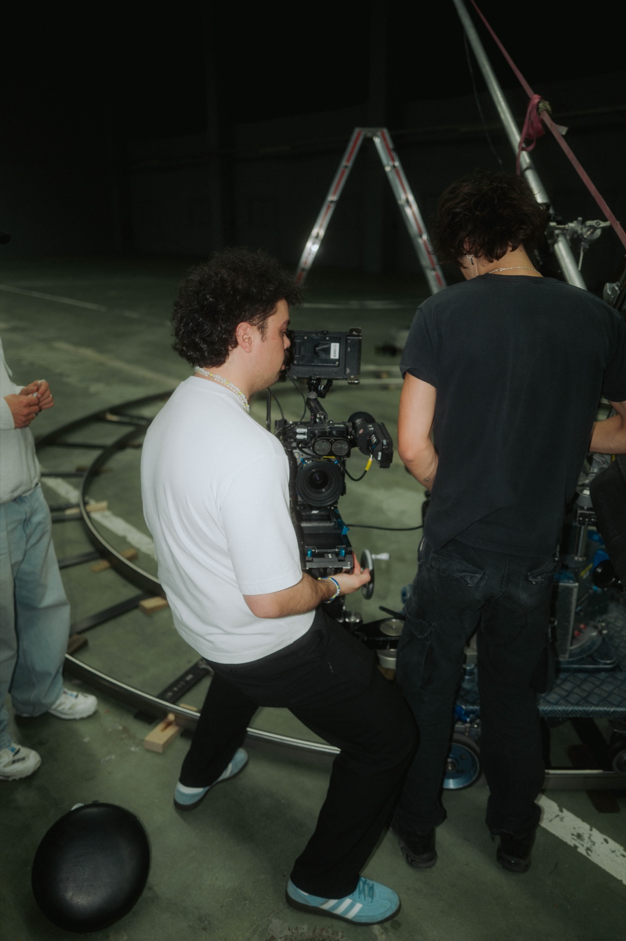 Kameramann fährt die ARRI auf dem Dolly, ein Crew-Mitglied hält gegen