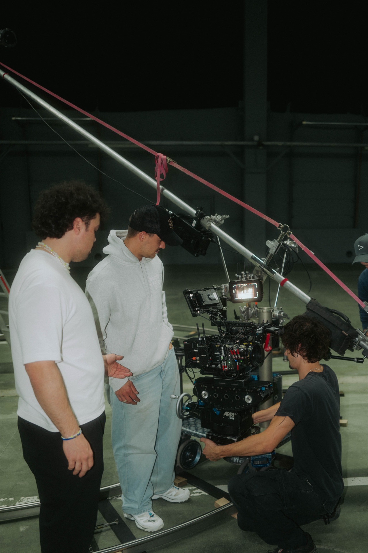 Die Crew schaut zu, während die Kamera auf dem Dolly eingestellt wird